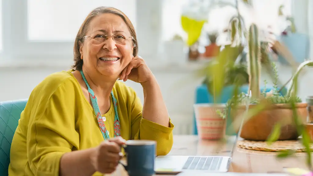 woman hold cup in-front of keyboard